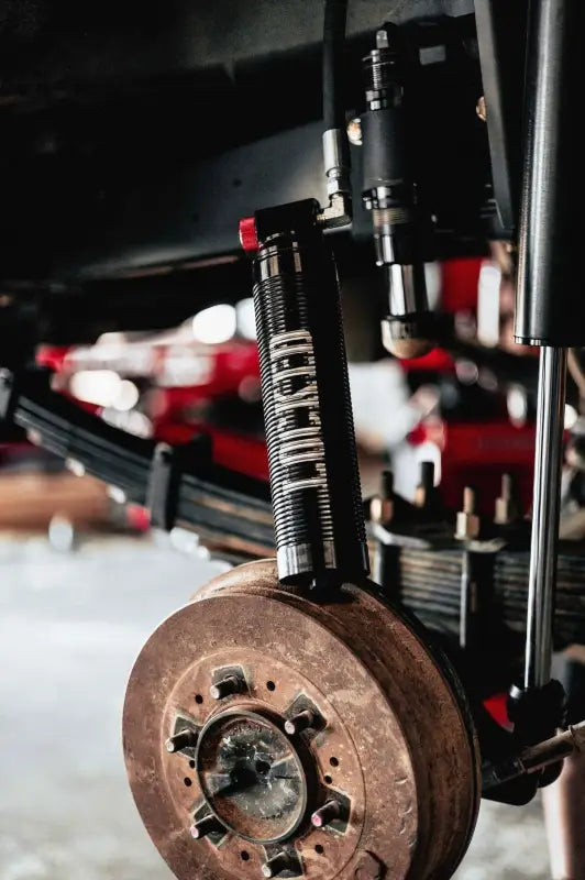 2.5-inch smooth body shock installed on a vehicle's rear suspension, showcasing off-road durability and compression adjusters.