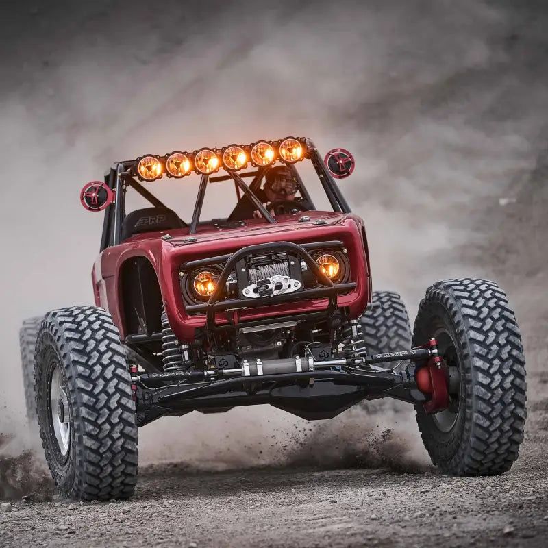 Red off-road vehicle equipped with 39-inch Titan™ LED Light Bar, showcasing bright illumination in rugged terrain.