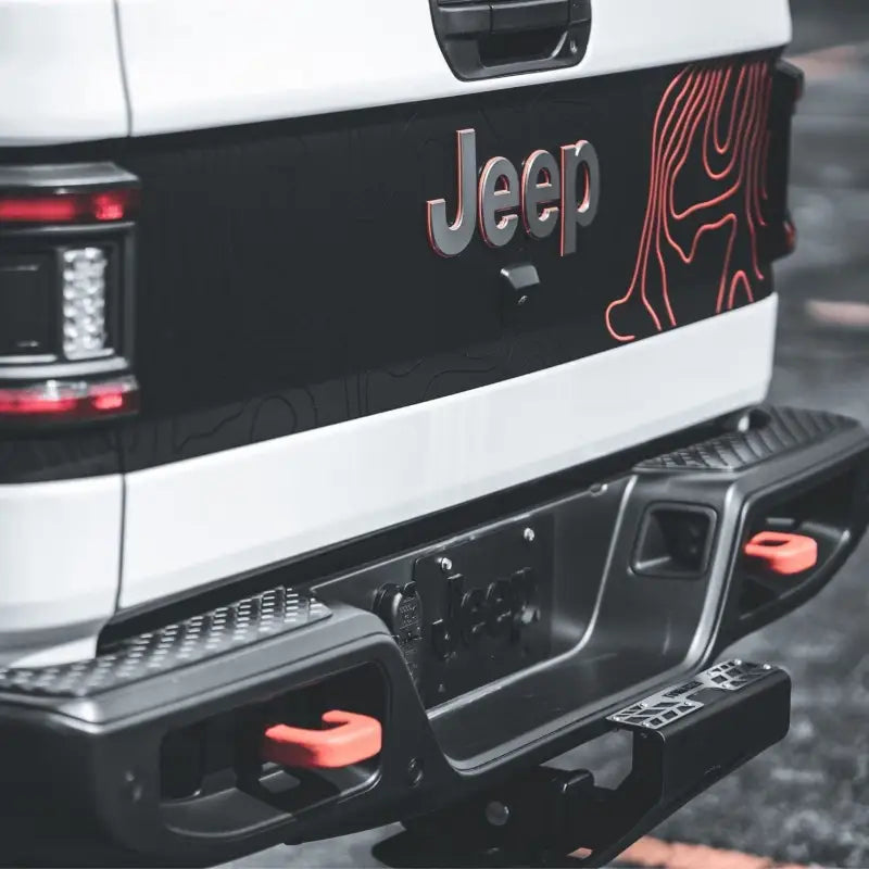 4CX Boar Hitch Step mounted on a Jeep rear bumper, highlighting its sleek design and compatibility with off-road accessories for added utility.