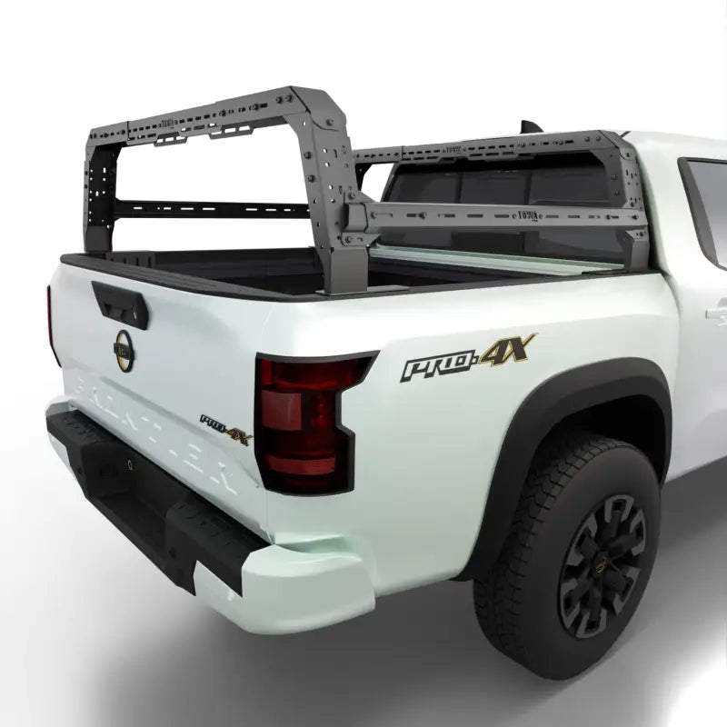 Nissan Frontier bed rack with adjustable height, mounted on a white truck. Durable Shiprock design for cargo and overlanding.