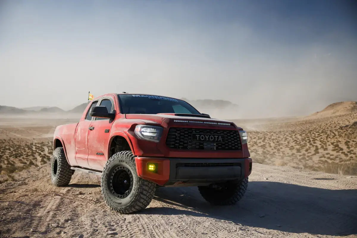 Red Toyota Tundra equipped with the 19-21 Magnum Supercharger System TVS2650, parked in a desert landscape for off-road performance display.