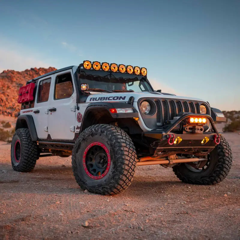 White Jeep Rubicon with the 50-inch Gravity Titan LED Light Bar mounted on the roof, parked in a desert at sunset.