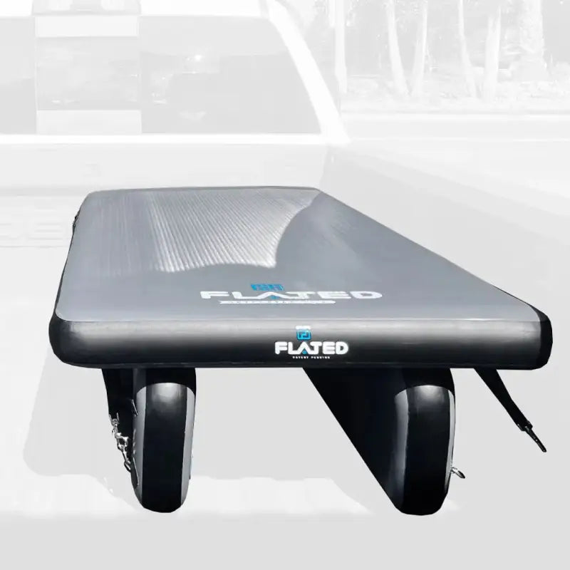 6' Cot - Portable Air-Deck inflated in a truck bed, showcasing durable design and secure tie-down points for vehicle storage.