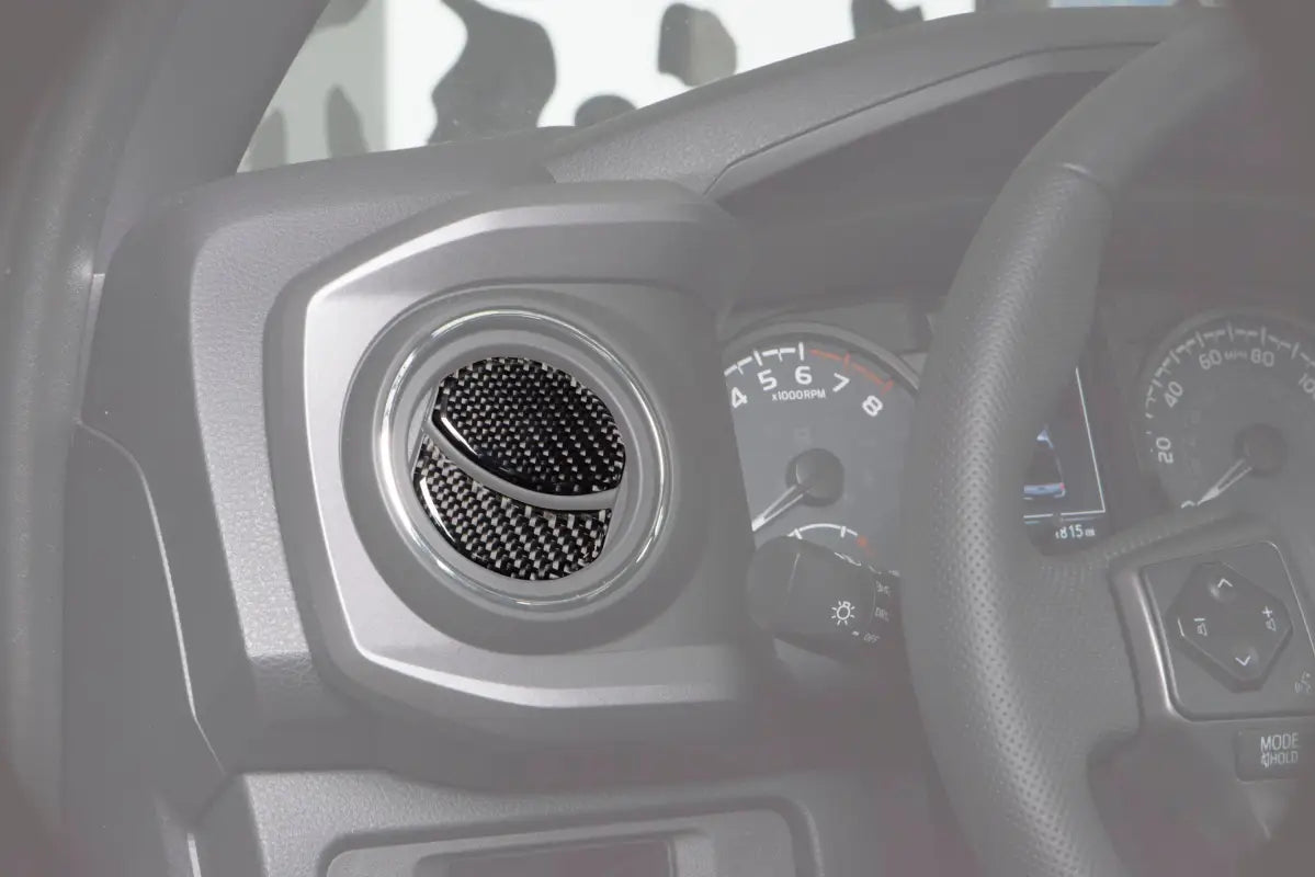 Close-up view of air vent accent trim installed on a 2016-2023 Toyota Tacoma dashboard, featuring a carbon fiber design for interior enhancement.