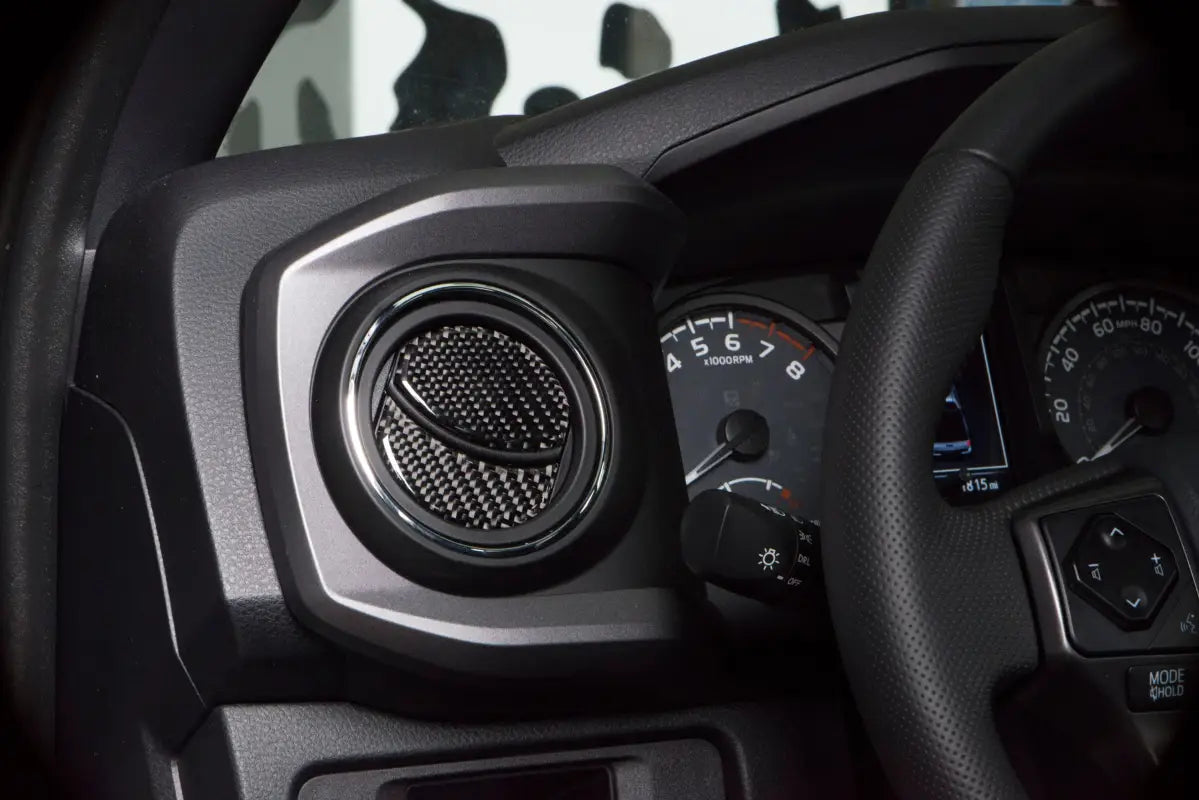 Detailed image of carbon fiber air vent accent trim fitted on a Toyota Tacoma dashboard, showcasing a sleek and modern interior upgrade.