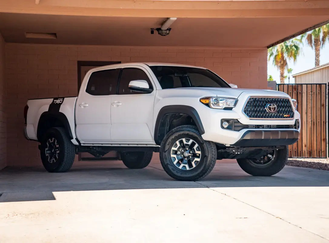 White Toyota Tacoma pickup truck with Alpha Bed Decals showcasing stylish bed decals