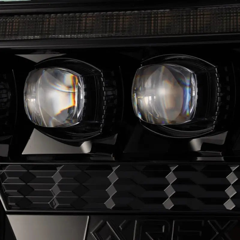 Close-up view of NOVA-Series LED projector headlights showcasing lens detail and hexagonal design for 2012-2015 Toyota Tacoma.