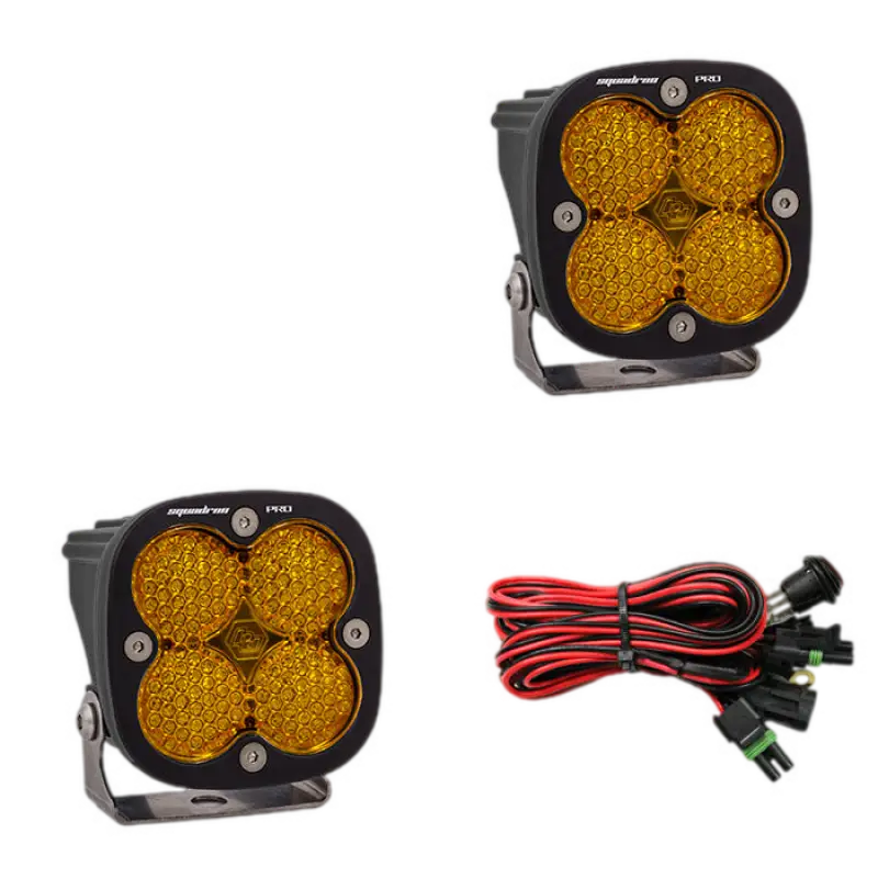 Baja Designs Squadron Pro LED light pods in black housing with amber lenses, showcasing durable design and included wiring harness.