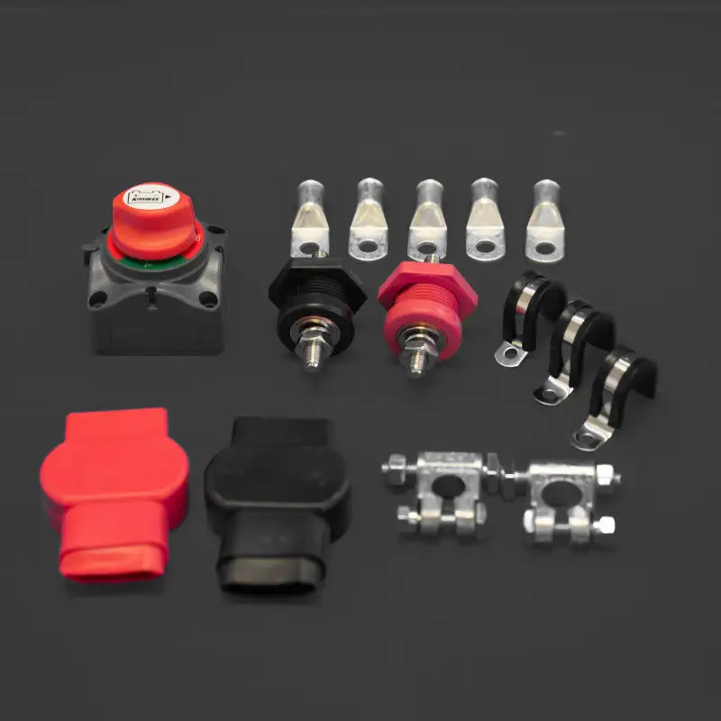 Essential hardware and components from the Toyota Tacoma battery relocate kit, including terminals, clamps, and protective covers.