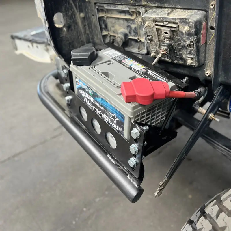 Side-mounted battery installation on a Toyota Tacoma using the JETG Designs battery relocate kit, featuring a NorthStar battery.