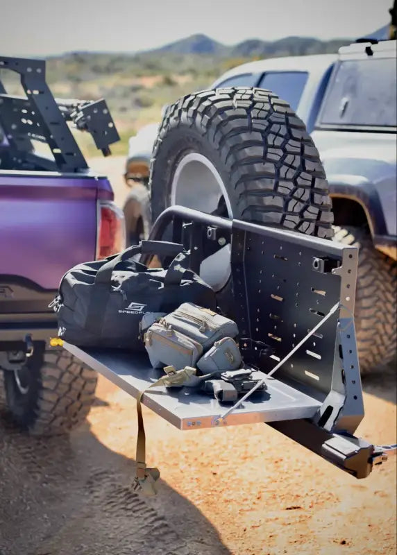 Tacoma bolt-on swing out with a foldable table, spare tire, and gear storage, ideal for off-road adventures.