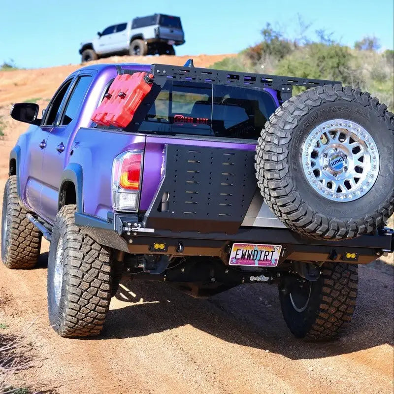 Tacoma bolt-on swing out with spare tire and gear mount on a purple truck, featuring a DRT bumper and off-road setup.