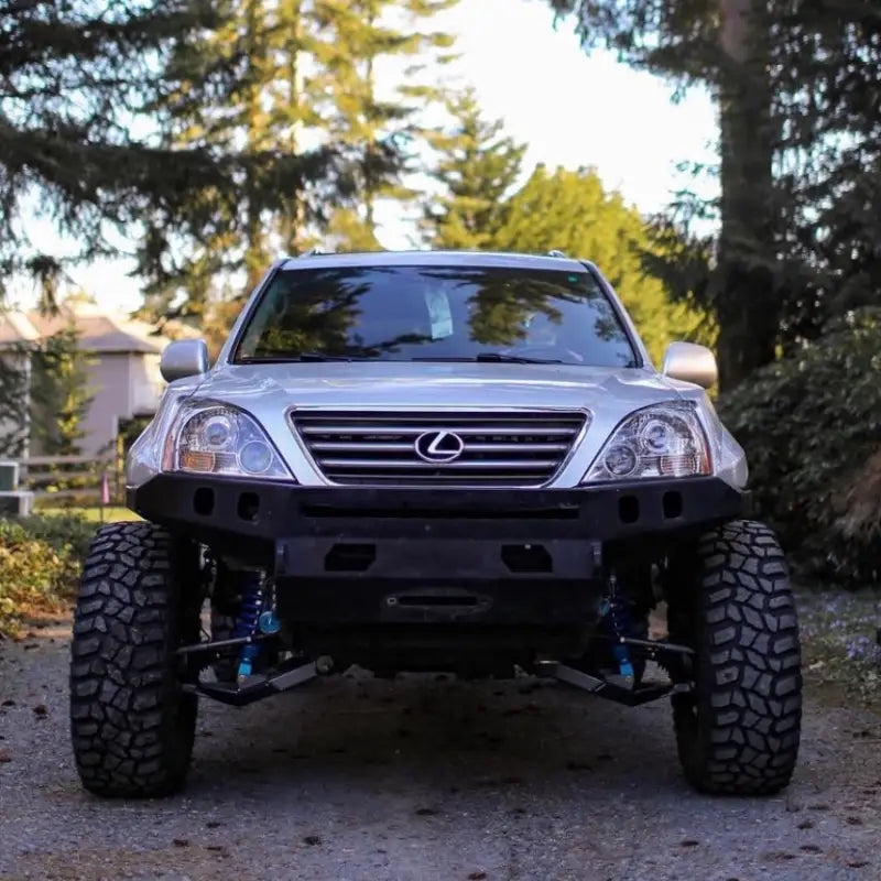 Front view of Lexus GX470 with +4.5 long travel suspension, off-road tires, and lifted stance in a forest setting.