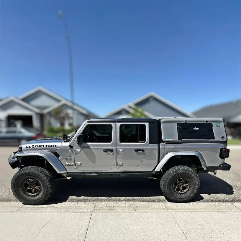 Silver Jeep Gladiator equipped with an Air-Topper truck cap, emphasizing its seamless fit and enhanced vehicle versatility.