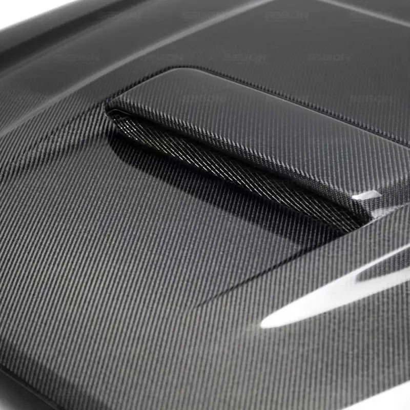Close-up of TR-Style carbon fiber hood for Toyota Tacoma 2016-2020, showcasing a sleek, glossy finish with a consistent weave and vented design.
