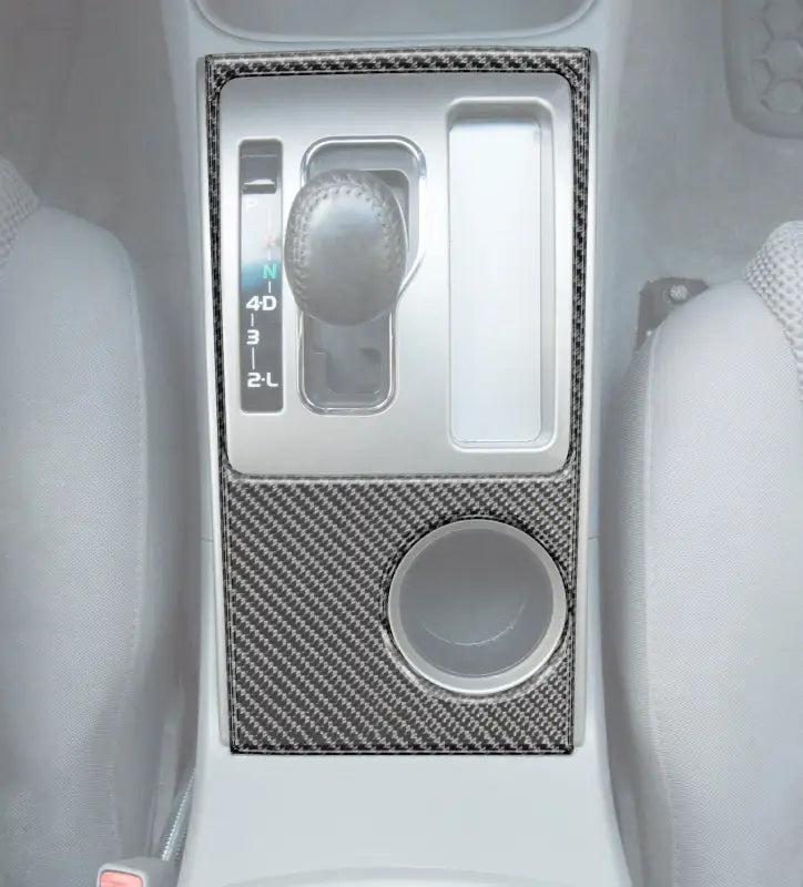 Carbon fiber-style center console accent overlay installed on a 2005-2015 Toyota Tacoma, enhancing the interior with a sleek design.