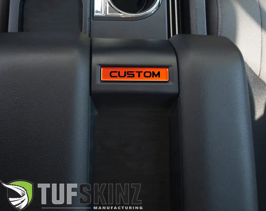 Inferno orange customizable center console badge installed in a 2014-2021 Toyota Tundra, providing a bold interior accent.