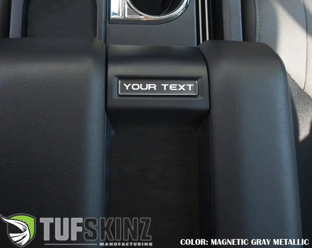 Magnetic gray metallic customizable center console badge installed in a 2014-2021 Toyota Tundra, enhancing interior decor.