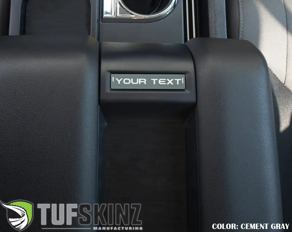 Cement gray customizable center console badge installed in a 2014-2021 Toyota Tundra, adding a subtle interior accent.