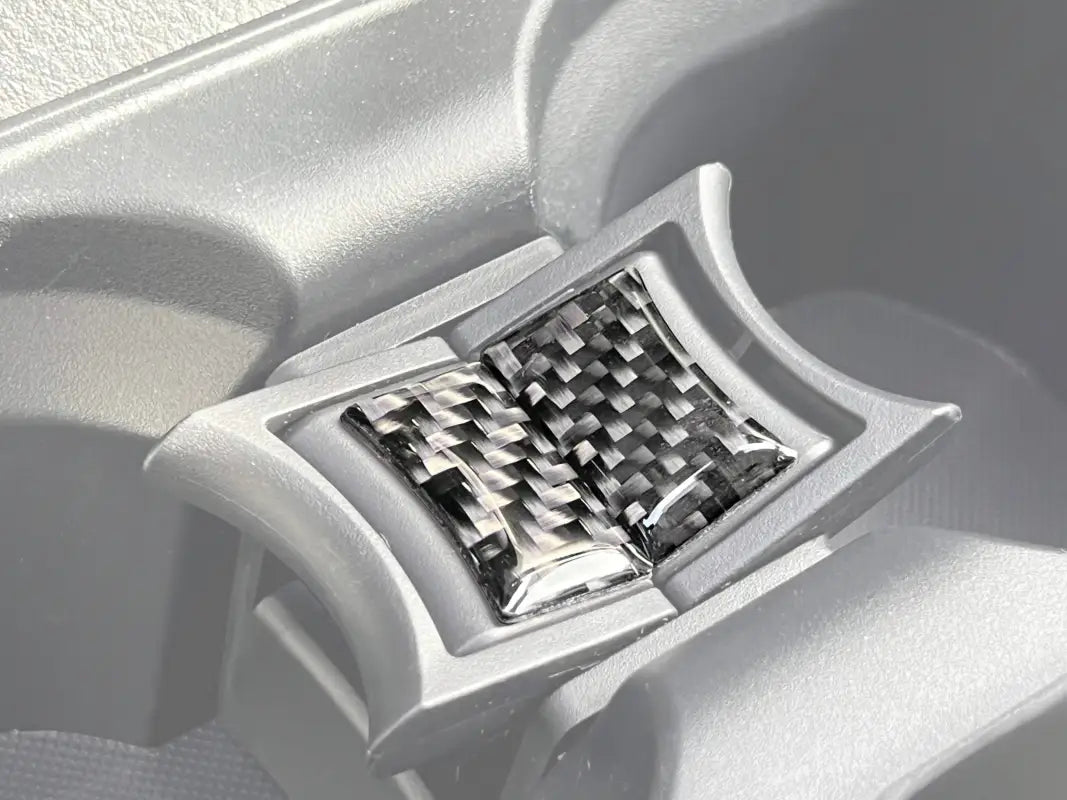 Center console cup holder divider overlays with carbon fiber texture installed in a 2016-2023 Toyota Tacoma interior.