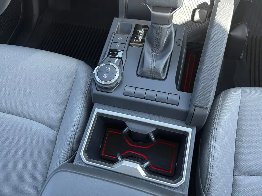 Close-up view of foam inserts with red accents fitted in the center console and cup holder of a 2024-2025 Toyota Tacoma for enhanced interior decor.