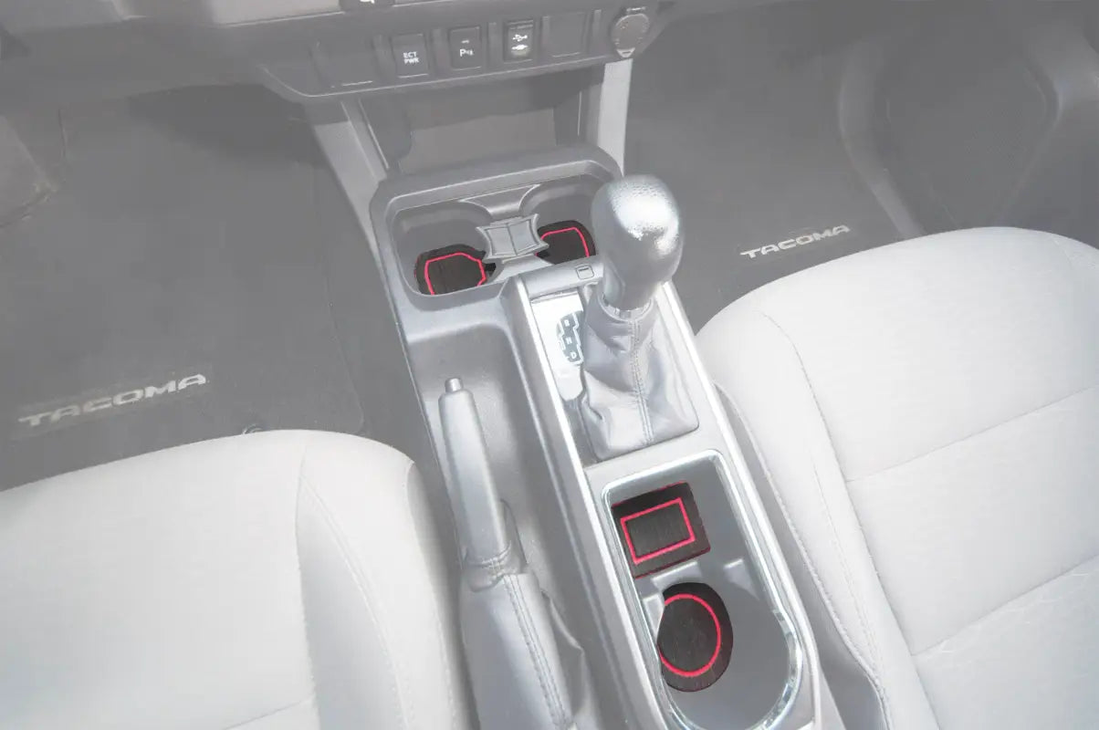 Center console cup holder inserts installed in a 2016-2023 Toyota Tacoma interior, featuring black foam with red trim for a custom fit.