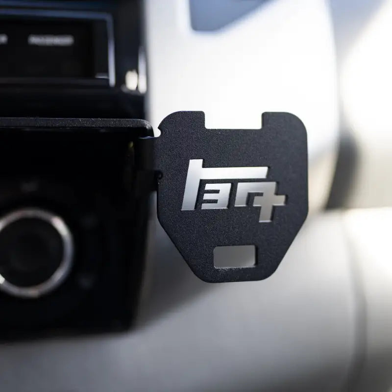 Close-up of a laser-cut TEQ logo attachment on the Tacoma modular accessory mount, showcasing precision craftsmanship.
