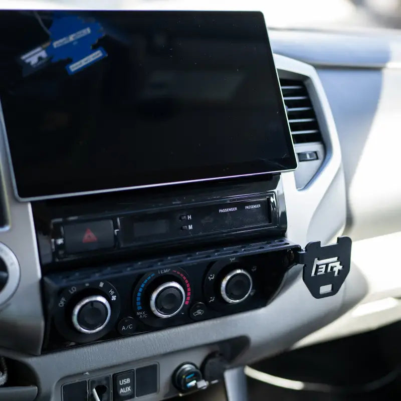Toyota Tacoma dashboard with a TEQ logo attachment on the modular accessory mount, blending functionality and style.
