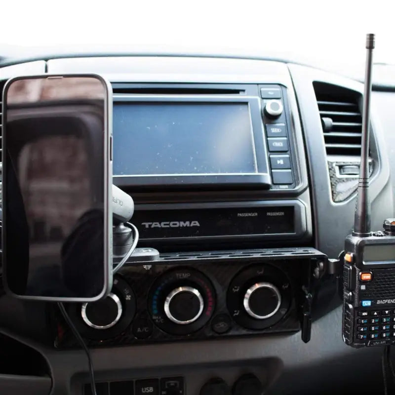 Toyota Tacoma dash mount with a phone holder and two-way radio attached, showcasing its customizable design.