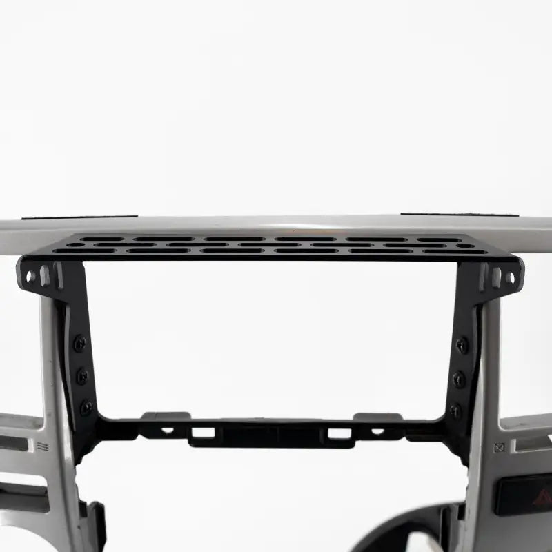 Top view of 4th Gen 4Runner modular dash mount installed on a console frame, highlighting its perforated design for accessory mounting.