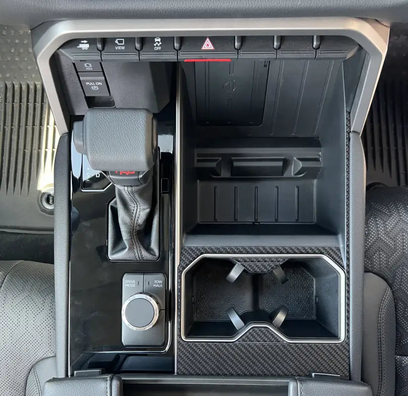 Close-up of center cup holder accent trim in a Toyota Tundra or Sequoia, highlighting the carbon fiber finish and precise fit.