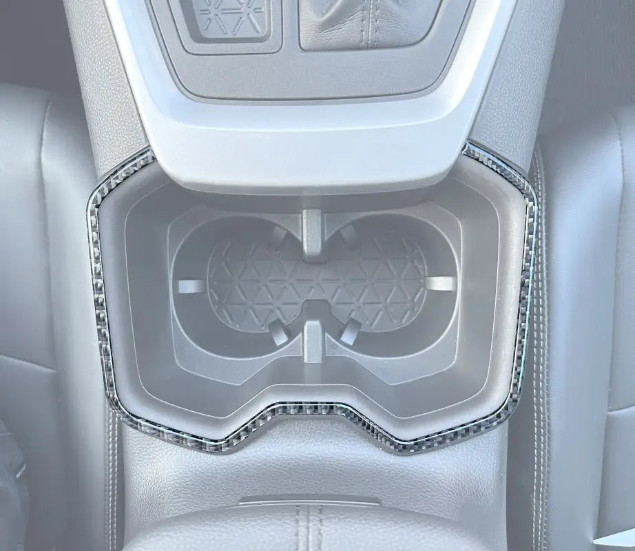 Center cupholder accent trim installed in a 2019-2024 Toyota Rav4 interior, showcasing a sleek carbon fiber design.