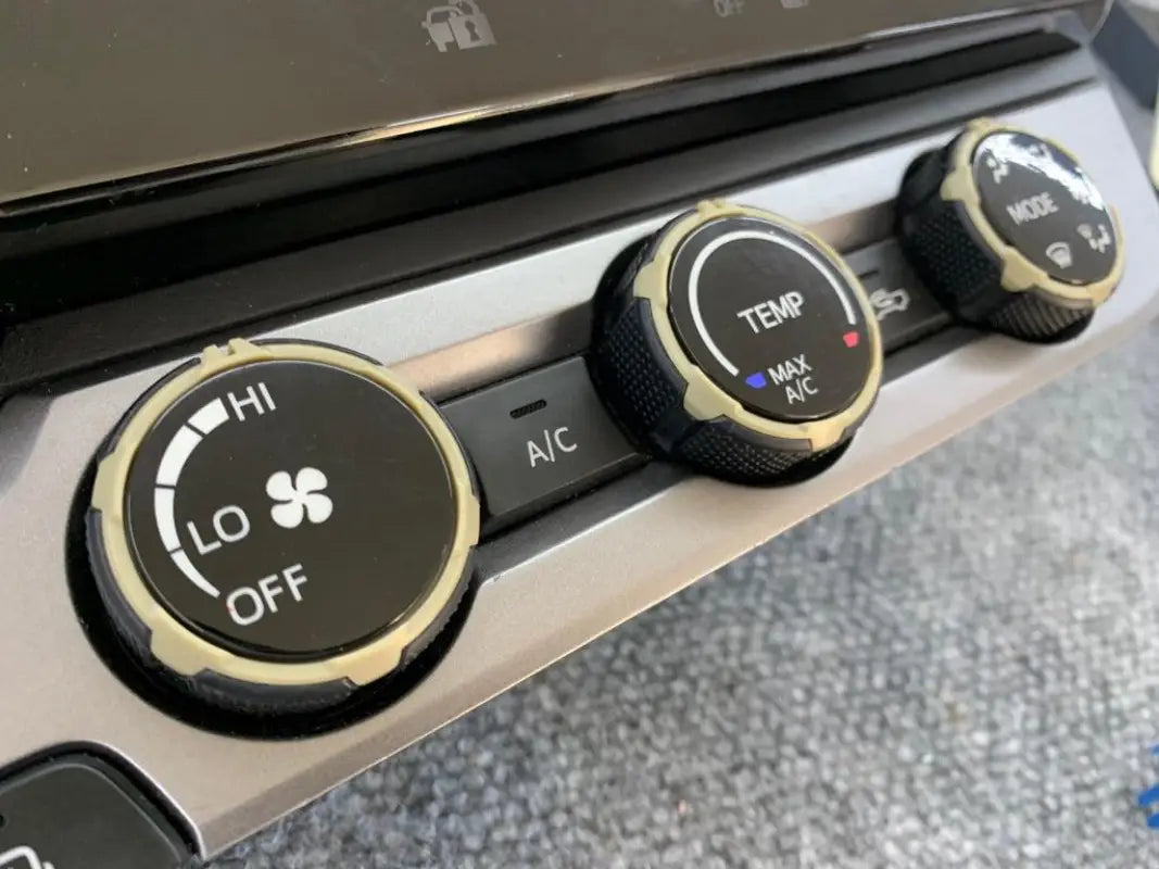 Tan climate control rings installed on 2016-2023 Toyota Tacoma dashboard, complementing interior design.