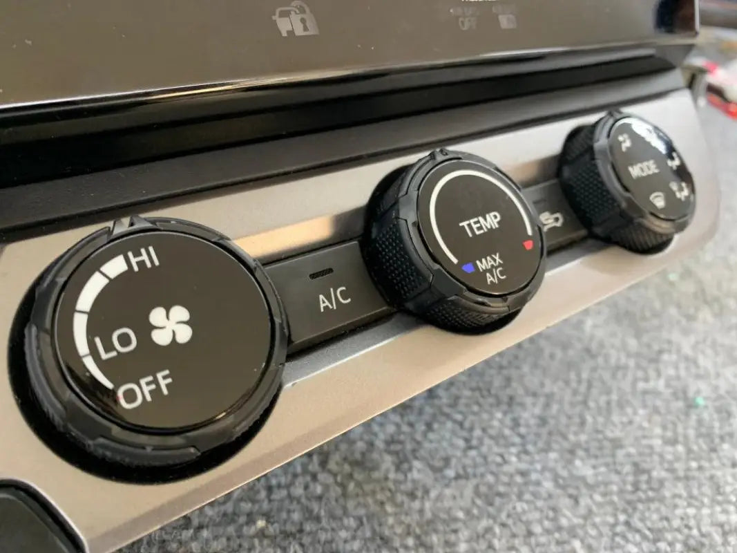 Dark gray climate control rings installed on 2016-2023 Toyota Tacoma dashboard, enhancing functionality.