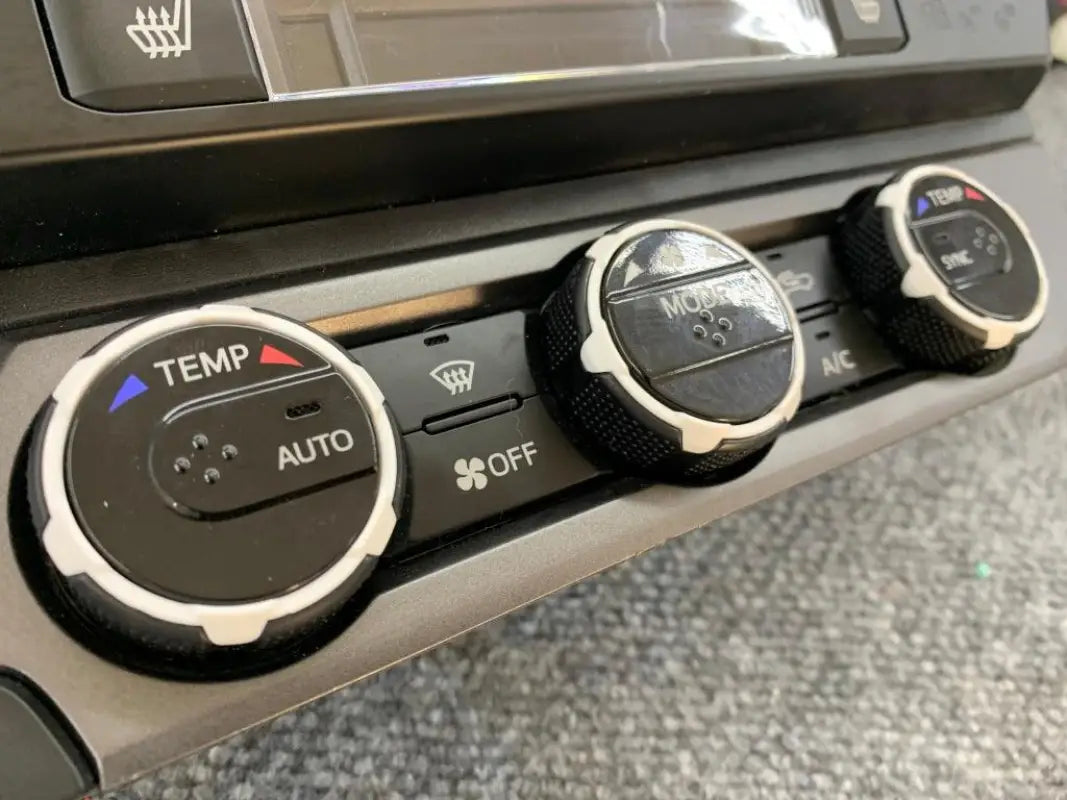 Tan climate control rings installed on digital climate controls of 2016-2023 Toyota Tacoma.