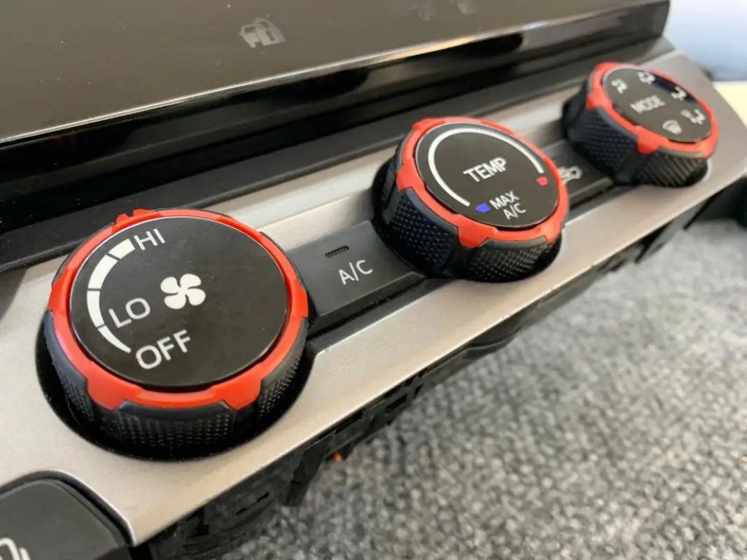 Red climate control rings installed on 2016-2023 Toyota Tacoma dashboard, enhancing interior style.