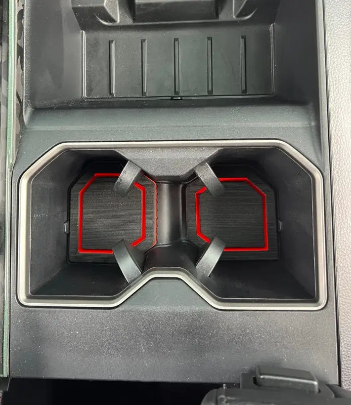 Cup holder foam inserts with red trim installed in a dual cup holder of a Toyota Tundra or Sequoia center console.