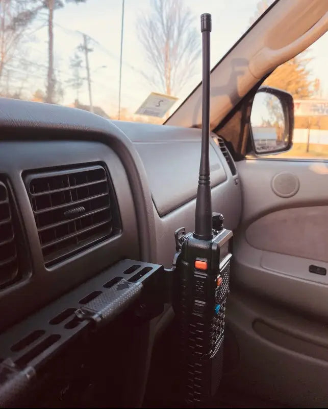Tacoma modular console mount holding a walkie-talkie, demonstrating off-road accessory compatibility for 98-04 models.