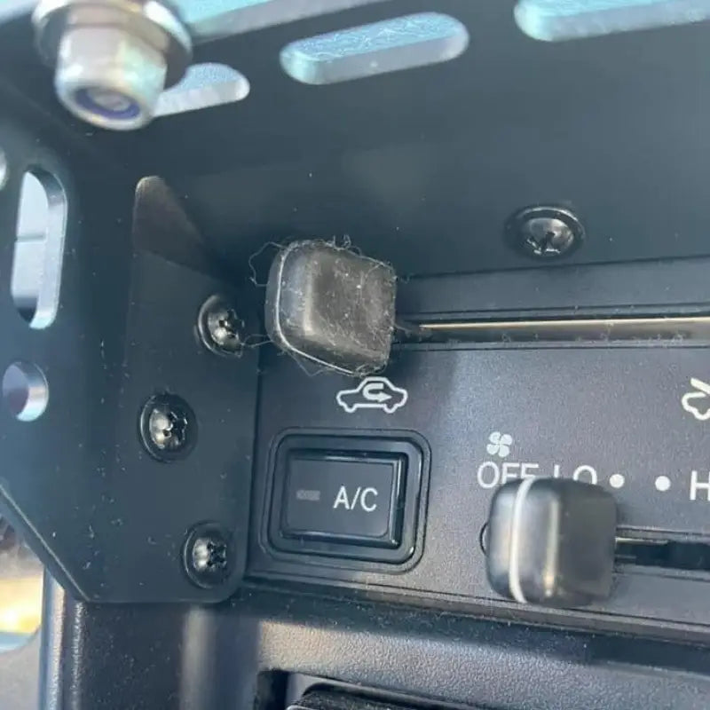 Close-up of Tacoma modular console mount installed on dashboard, showing secure fit and accessory compatibility for 98-04 models.
