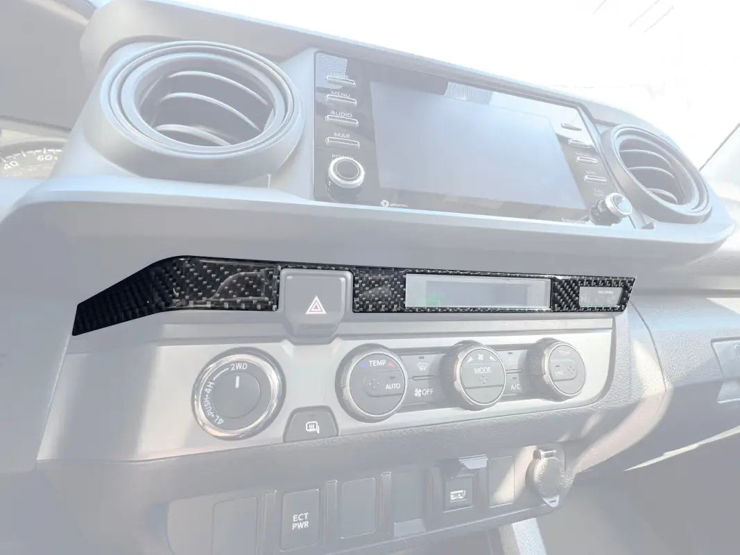 Digital Climate Display Accent Trim installed on a 2016-2023 Toyota Tacoma dashboard, featuring a carbon fiber finish for a sleek interior upgrade.