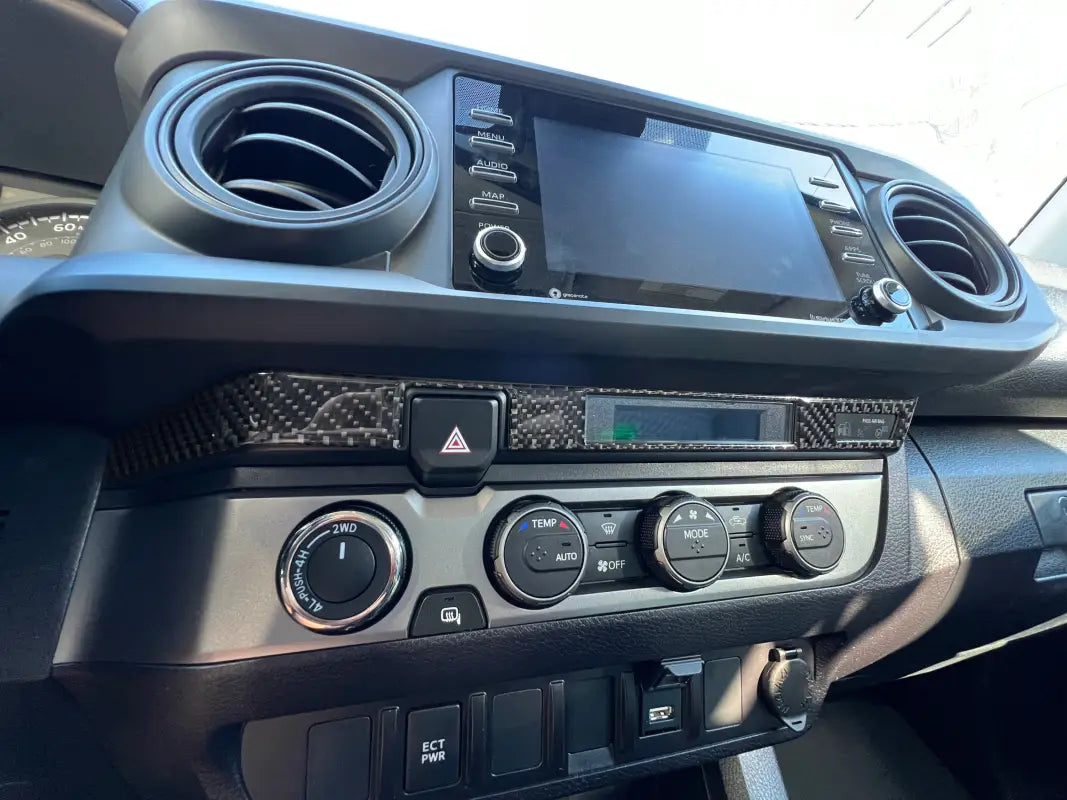Close-up view of the Digital Climate Display Accent Trim in carbon fiber finish, seamlessly integrated into a 2016-2023 Toyota Tacoma dashboard.