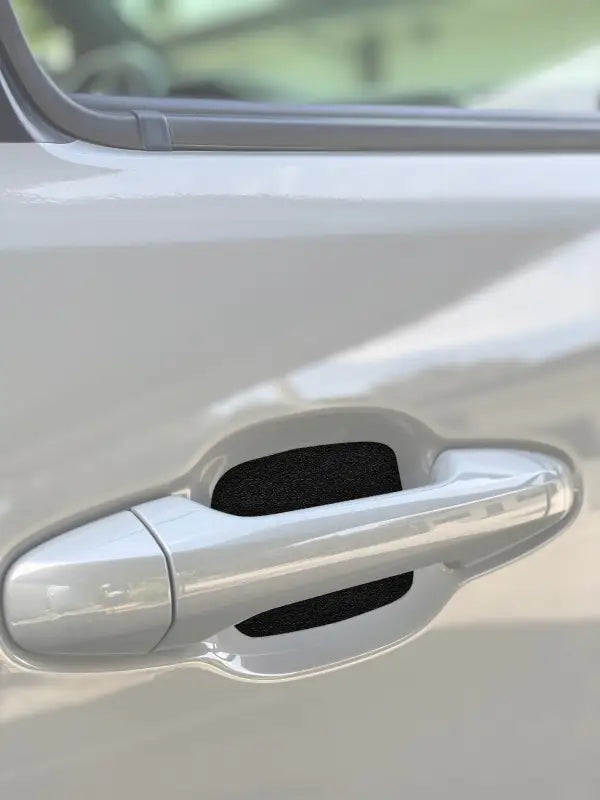 Black textured door handle protective insert installed on a 2016-2023 Toyota Tacoma or 2010-2024 Toyota 4Runner, enhancing durability and style.