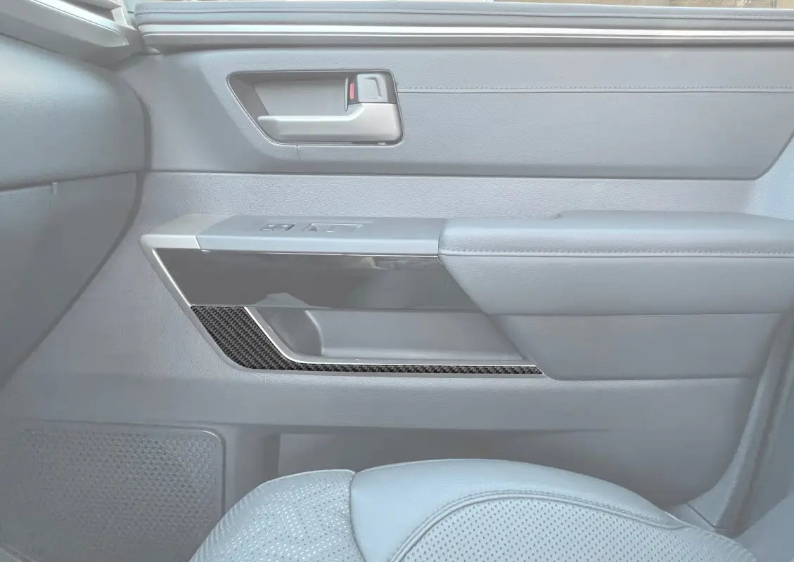 Door lower accent trim installed on the interior of a 2022-2024 Toyota Tundra, featuring a sleek carbon fiber design for enhanced style.