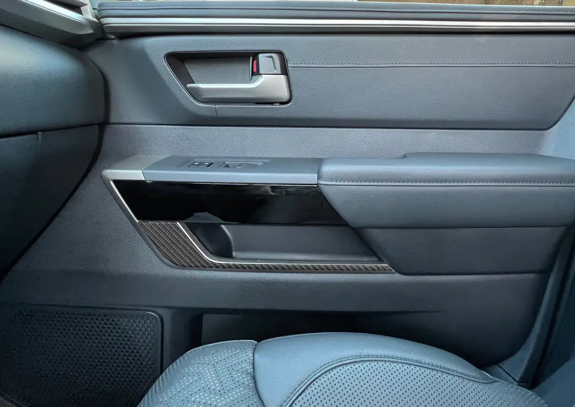 Close-up of door lower accent trim on a 2022-2024 Toyota Tundra interior, showcasing a premium carbon fiber finish.
