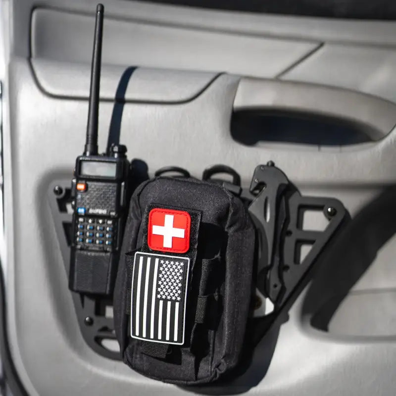 2nd Gen Tacoma molle panel with mounted first aid pouch, radio, and knife, demonstrating accessory compatibility for 2012-2015 models.