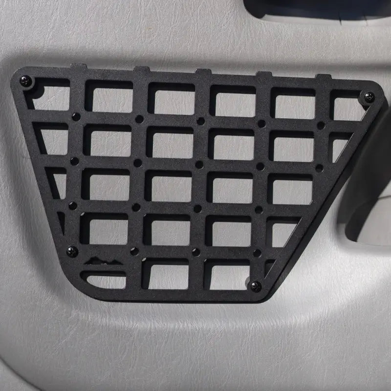 Close-up of the 2nd Gen Tacoma molle panel installed on a door, showcasing its precision-cut aluminum grid for 2012-2015 models.