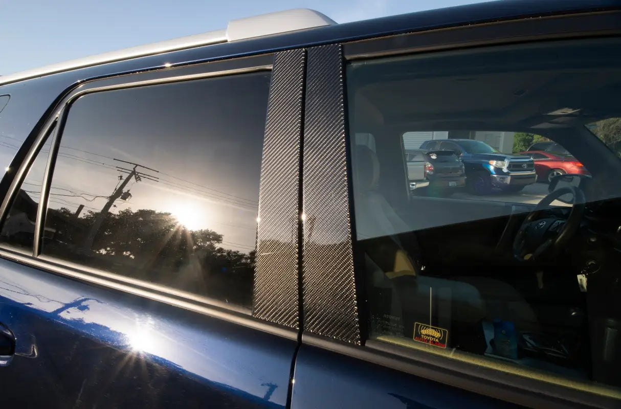 Raw carbon fiber door pillar accent trim installed on a Toyota 4Runner, reflecting a premium and sporty finish.