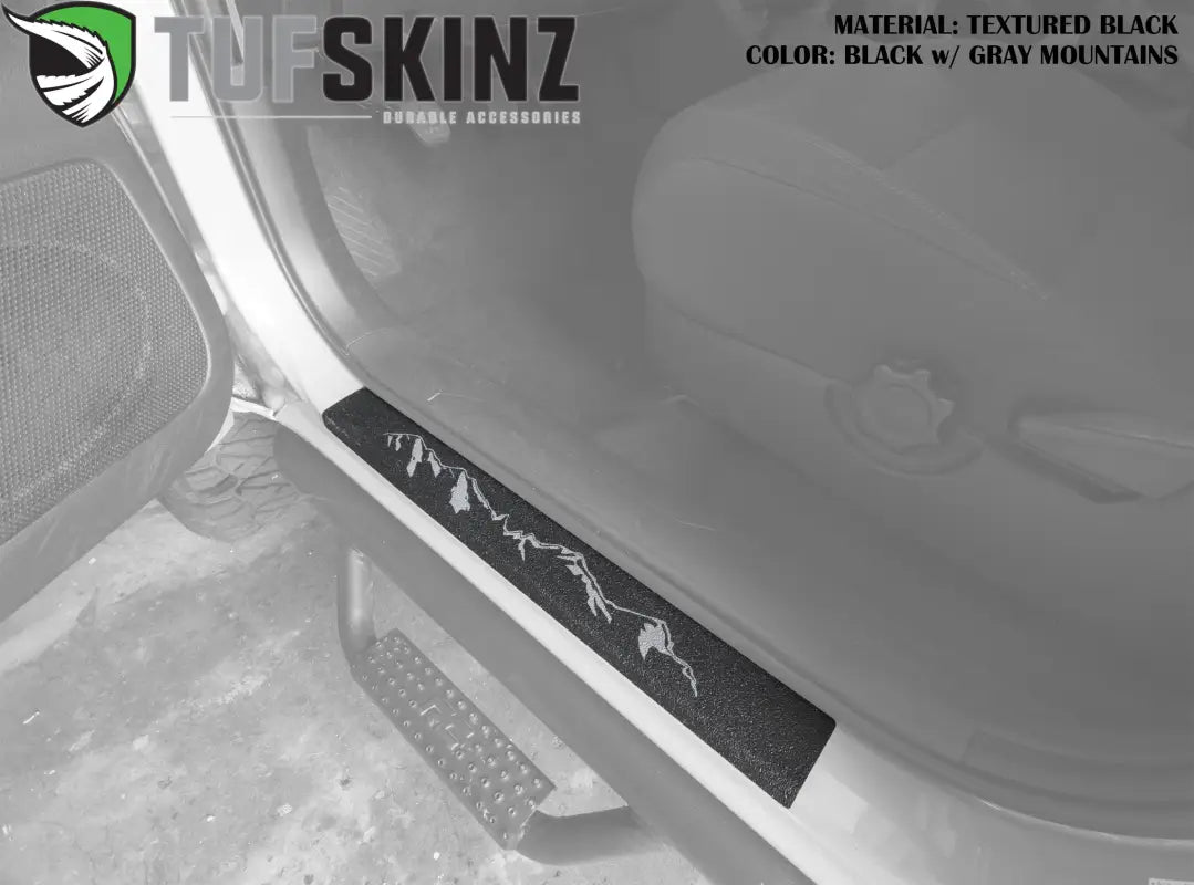 Textured black door sill overlay with gray mountain design for 2005-2023 Toyota Tacoma, combining style and protection.