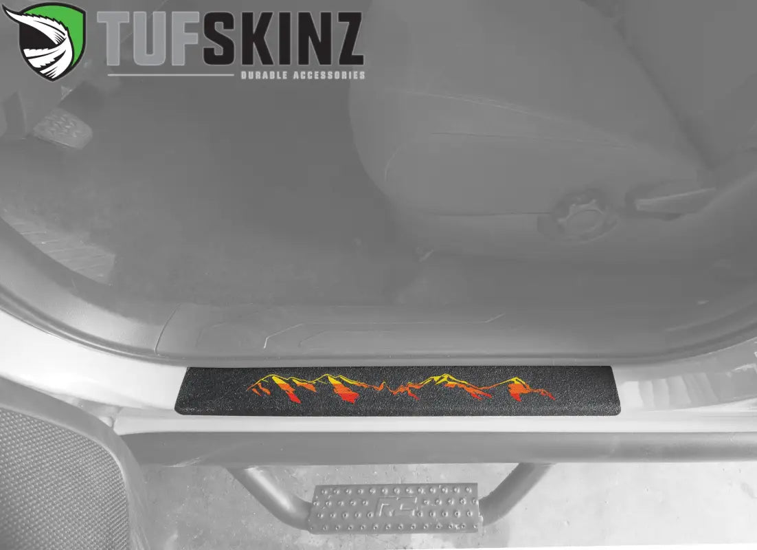 Textured black door sill overlay with red and yellow mountain design for 2005-2023 Toyota Tacoma, adding a bold interior accent.