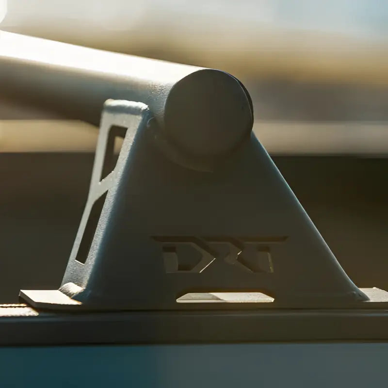 Close-up of DRT Tacoma Lo-Pro Bedbars laser-cut steel bracket with DRT logo, showcasing precision engineering and durability.